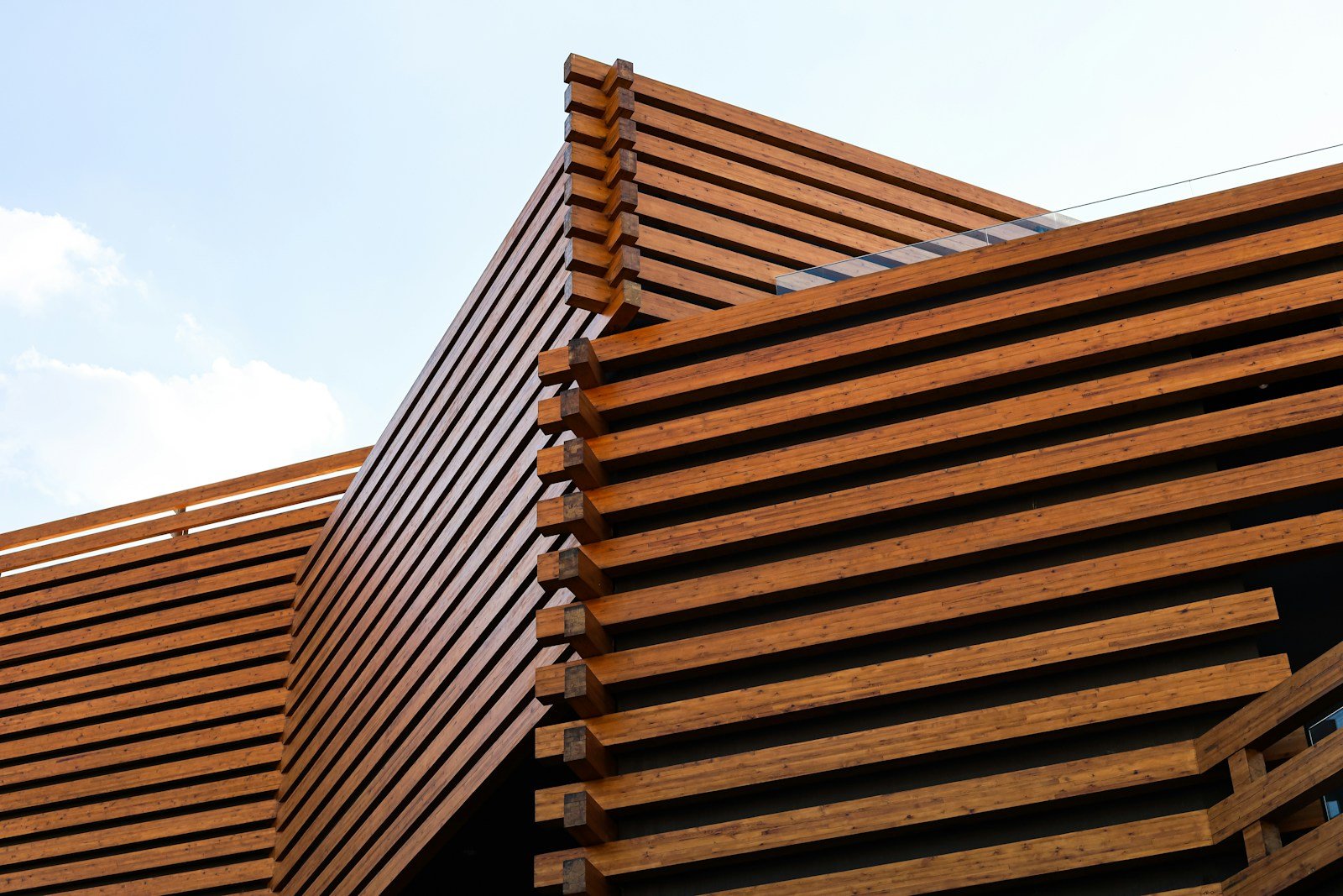 Brise-soleil en bois filtrant la lumière sur une façade