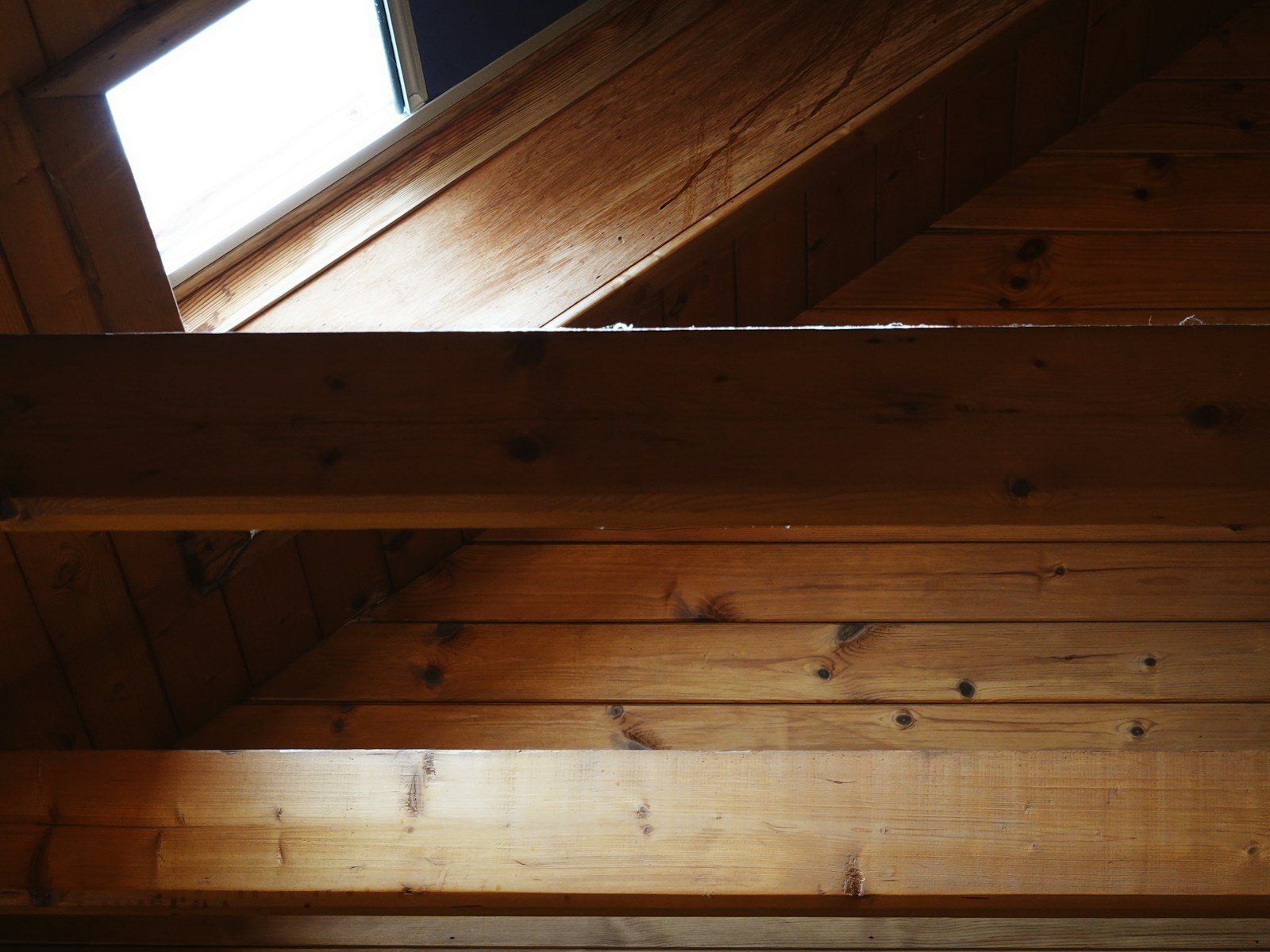 Combles rénovés avec un plancher en bois fini et lumineux