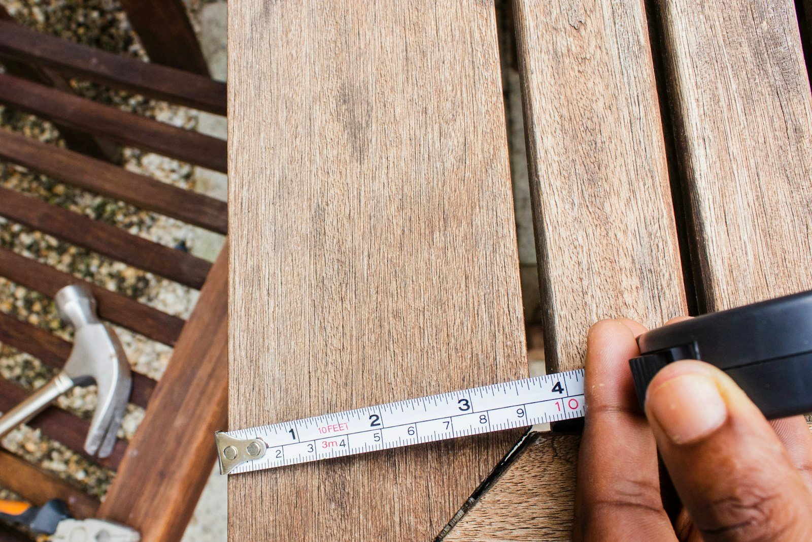 Inspection des lames d'une terrasse en bois avant rénovation
