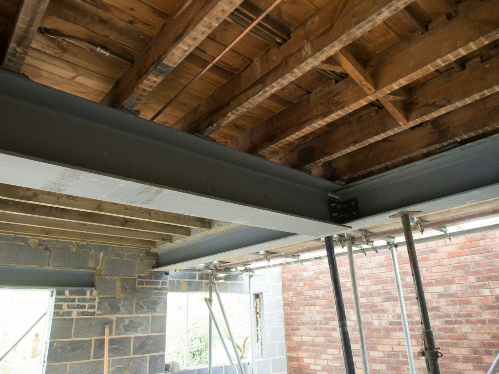 Linteau en bois visible au-dessus d'une ouverture de porte en cours de rénovation