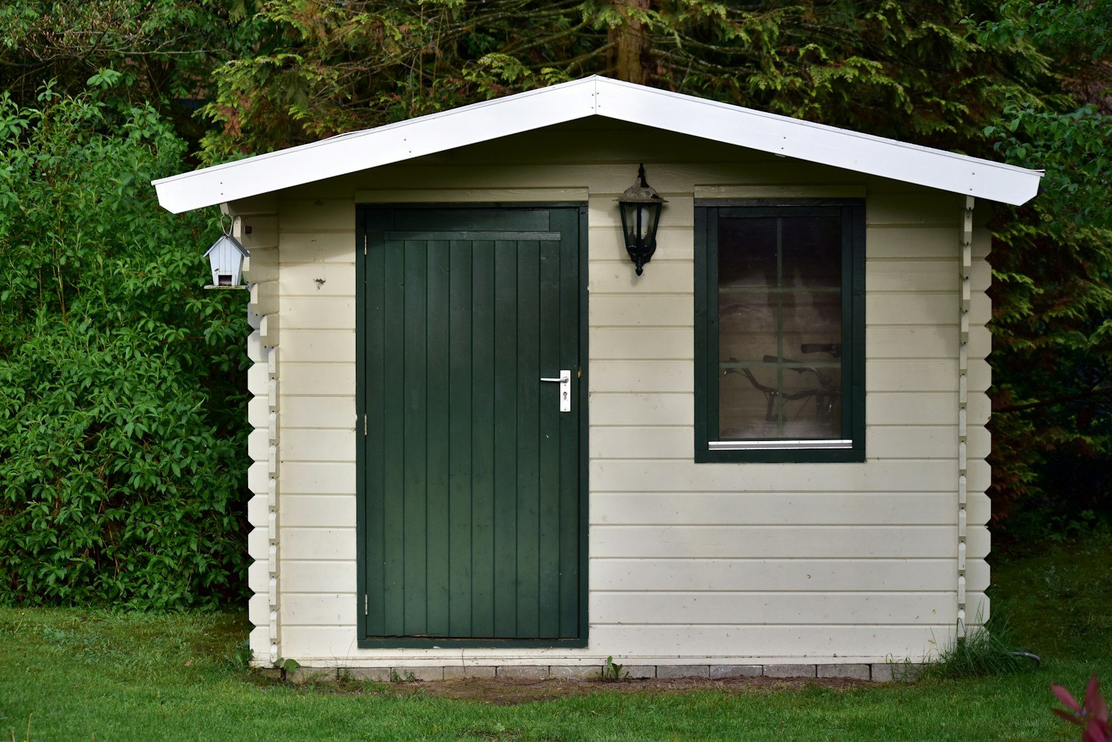 Petit bungalow en bois installé au fond d'un jardin