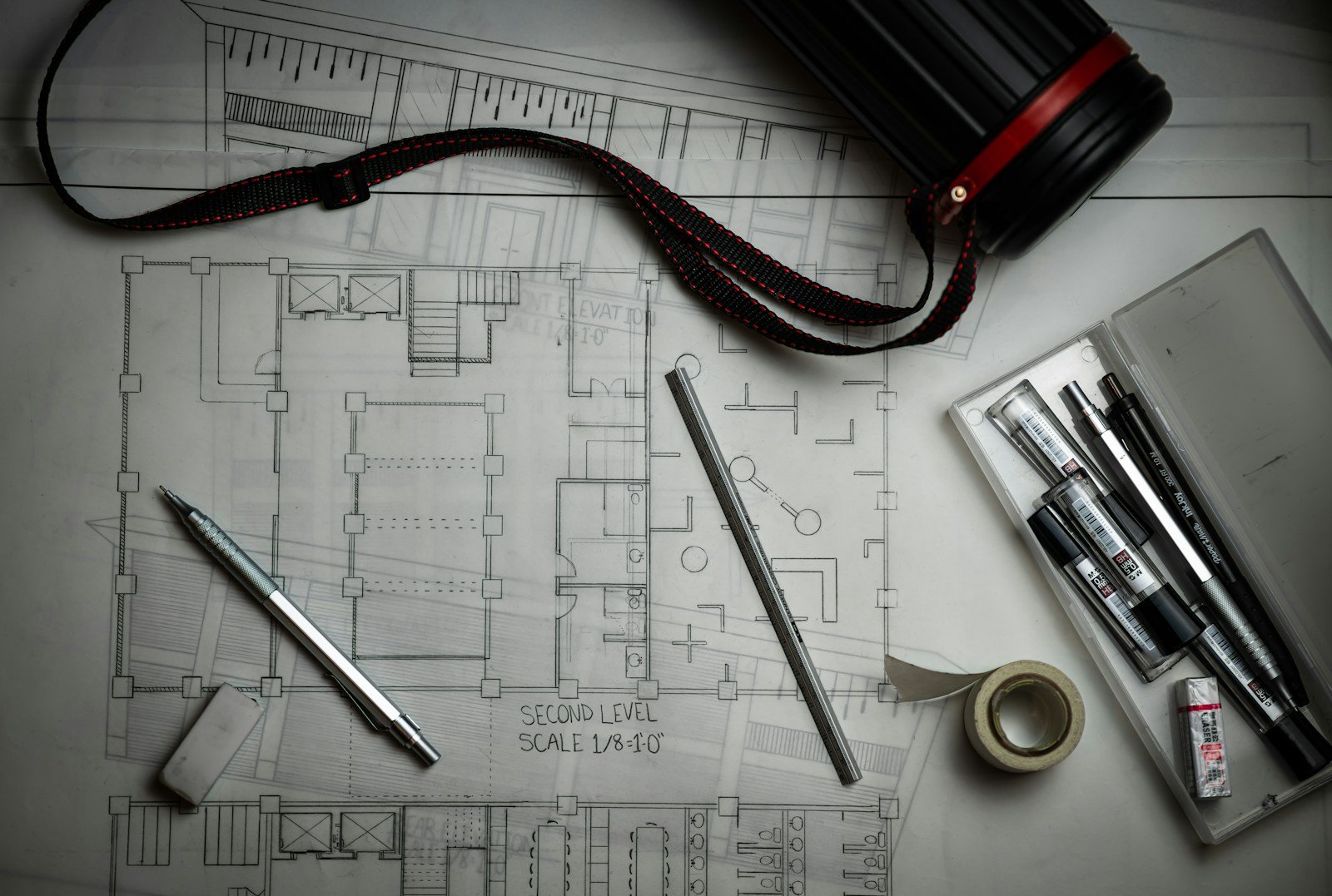 Plan de maison dessiné, posé sur une table de travail