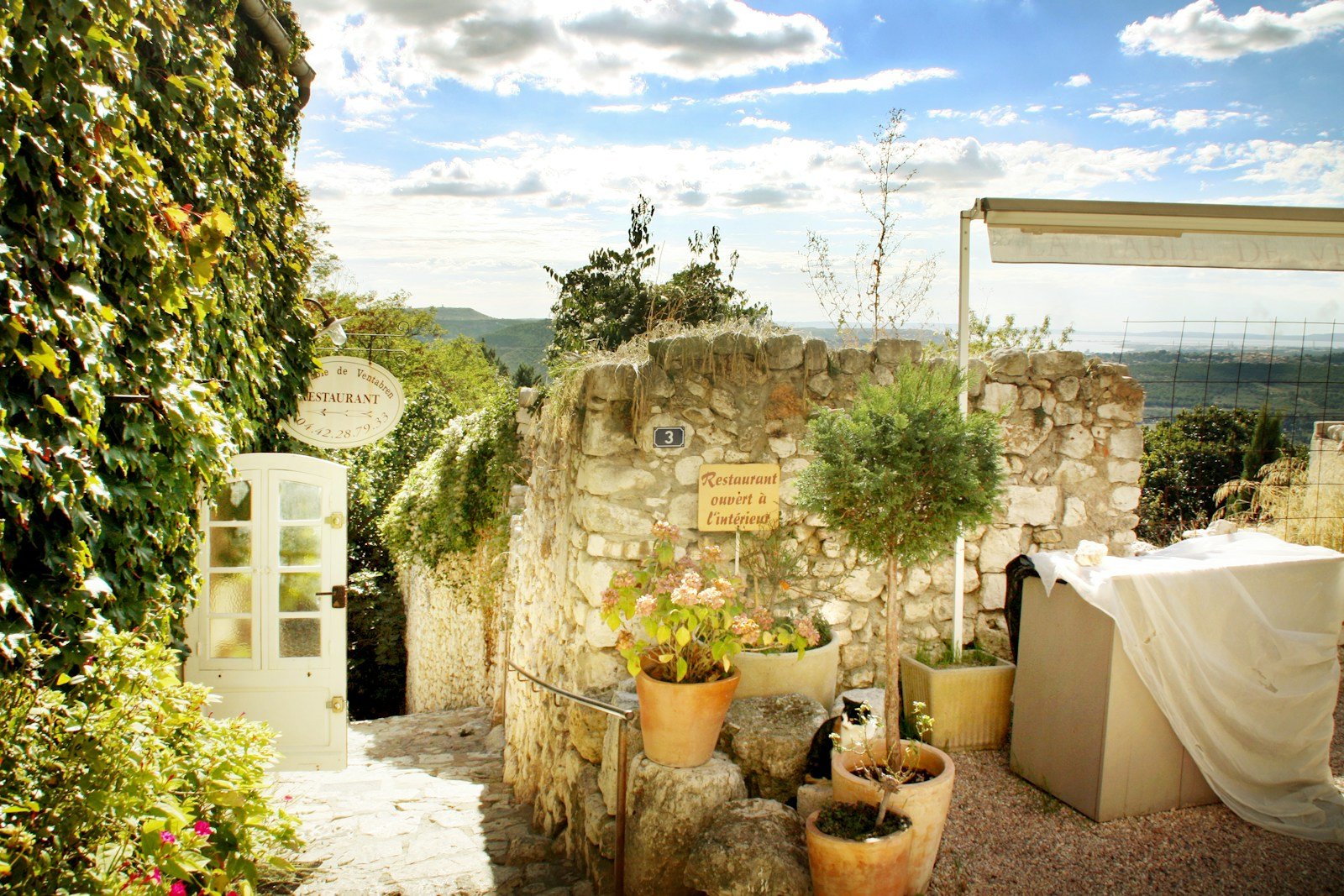 Terrasse couverte décorée de pots en terre cuite et de plantes